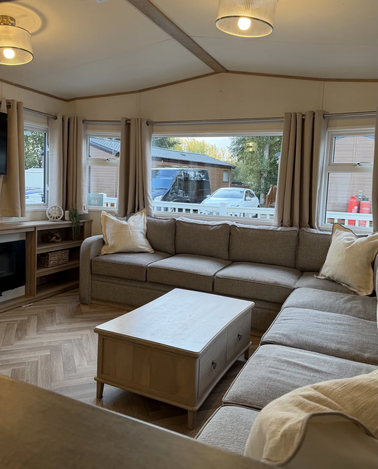 Cosy lounge with grey corner sofa, coffee table and panoramic windows