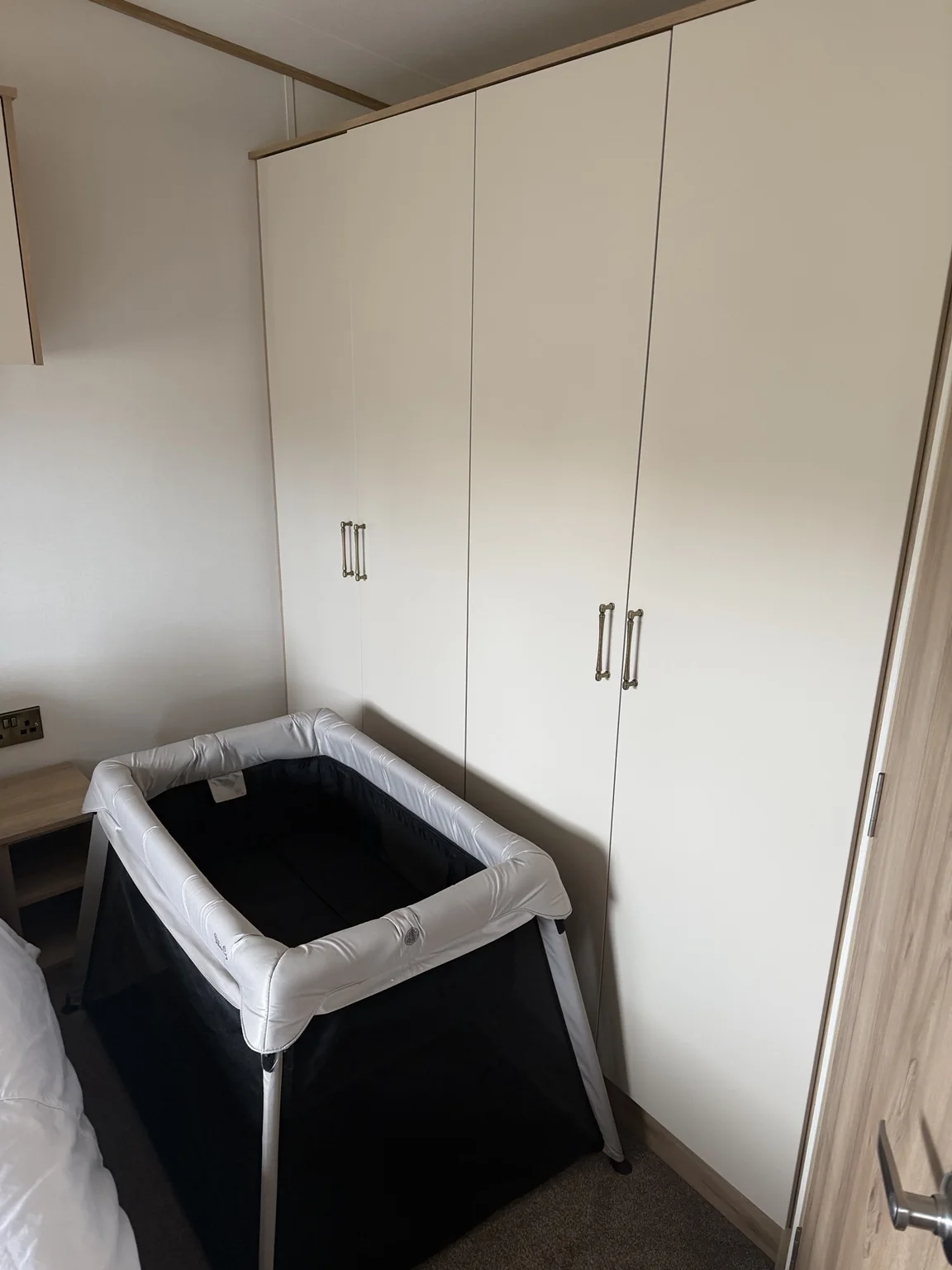 Travel cot set up next to the main bedroom wardrobes