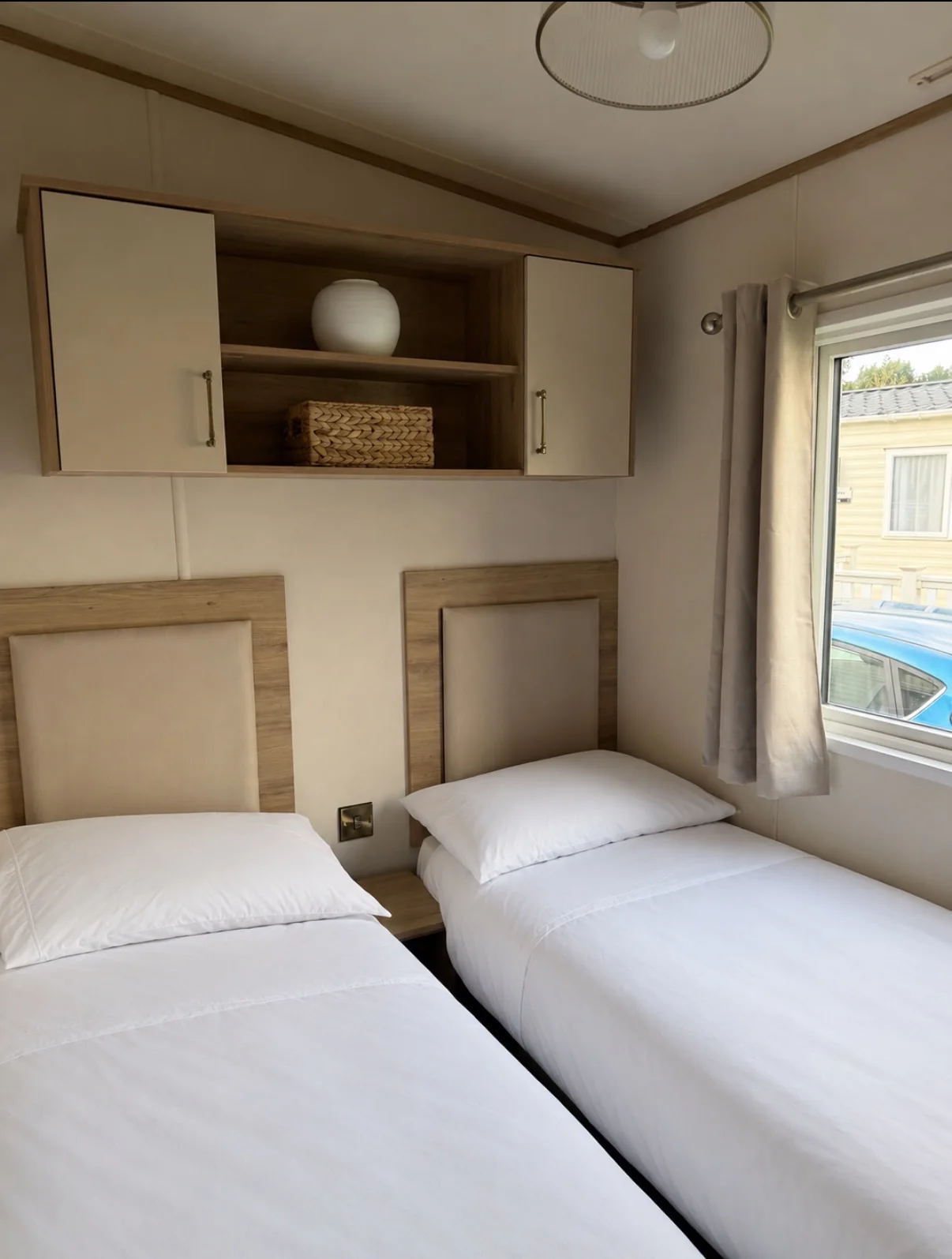 Twin bedroom with two single beds and fitted overhead storage
